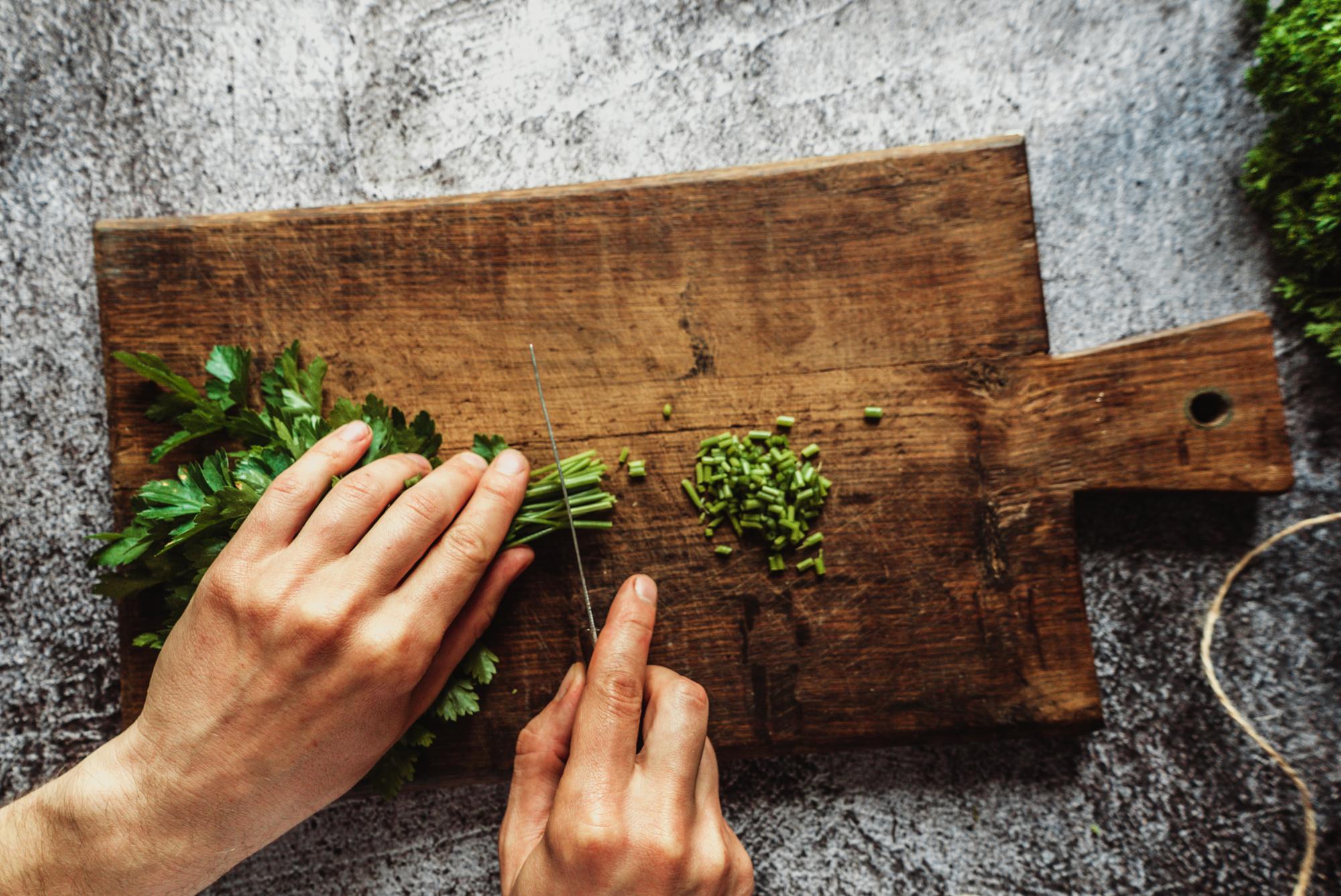 Close-up of hand-cut herbs on wooden board